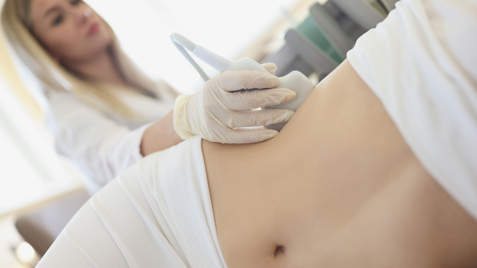 Doctor doing ultrasound examination of kidneys to woman patient in clinic closeup,Doctor doing ultrasound examination of kidneys to woman patient 