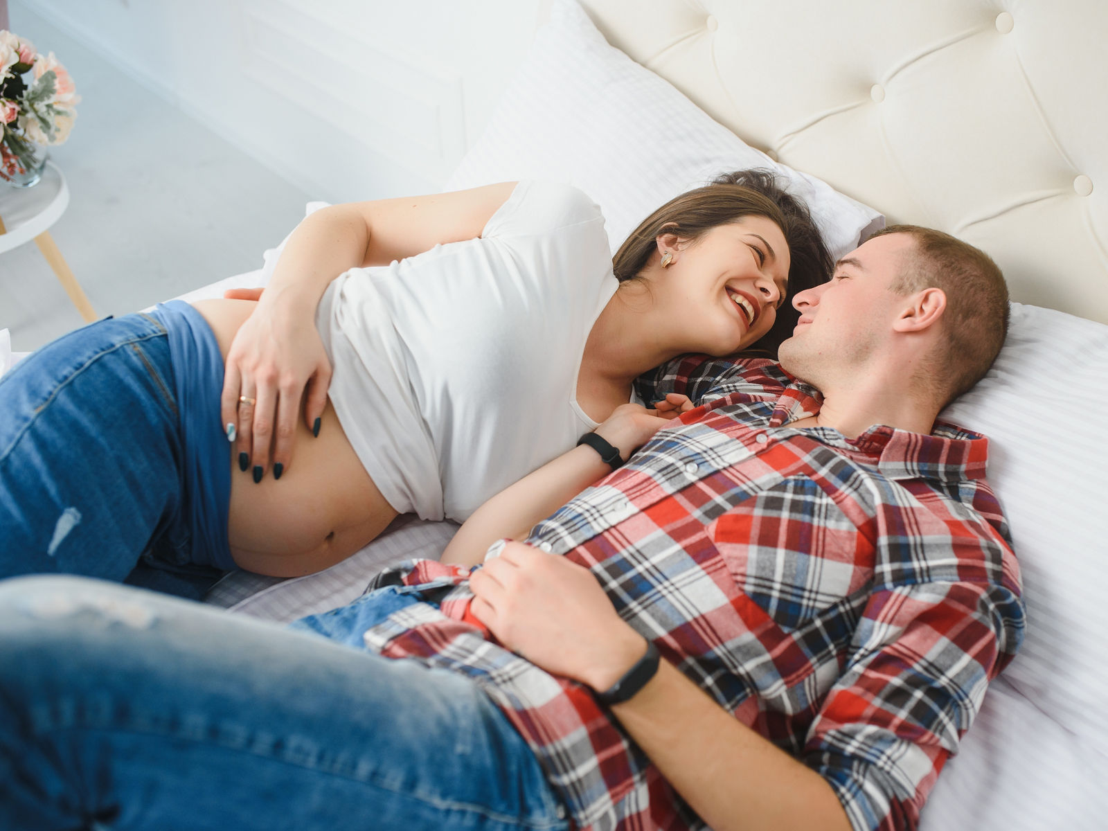 Young pregnant woman with husband on sofa in room