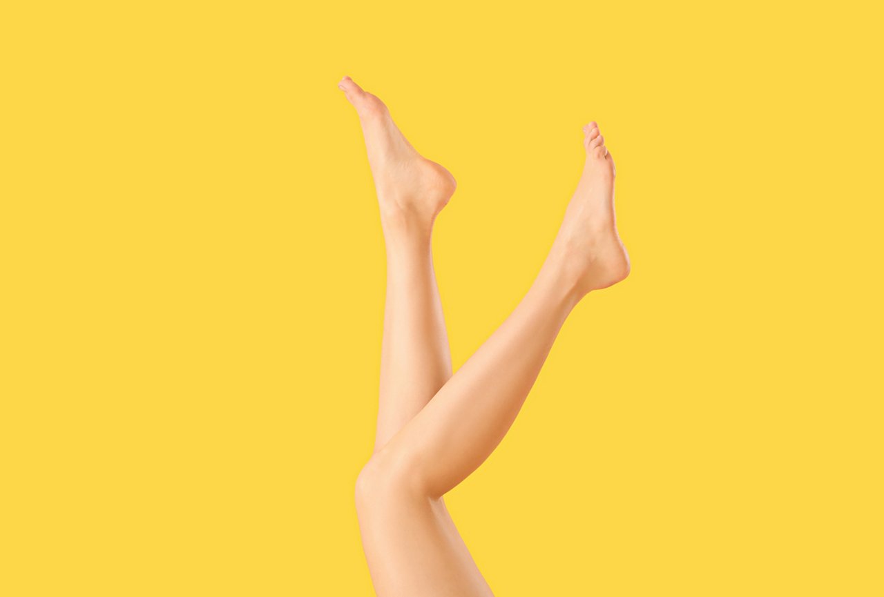 Beine einer Frau auf gelb/orangenem Hintergrund