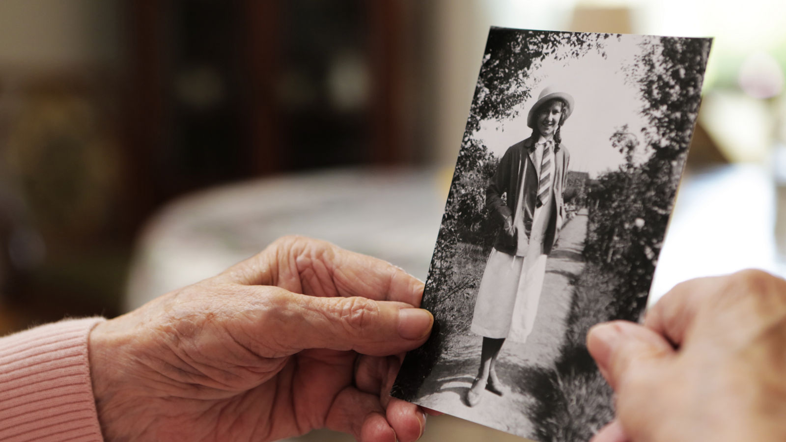 Seniorin mit altem Foto aus ihrer jugend 