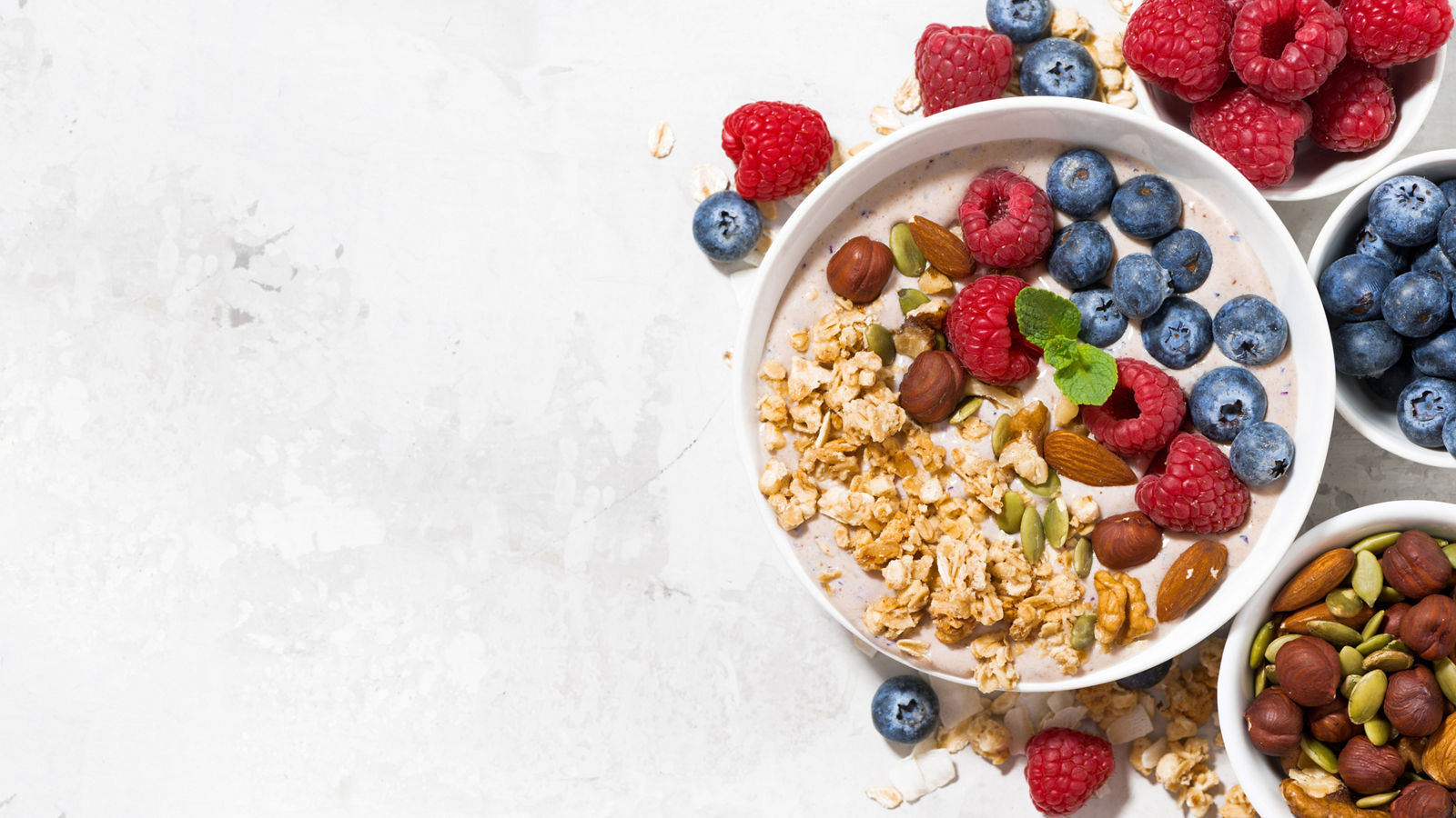 muesli with yogurt and berries for breakfast on white background, top view