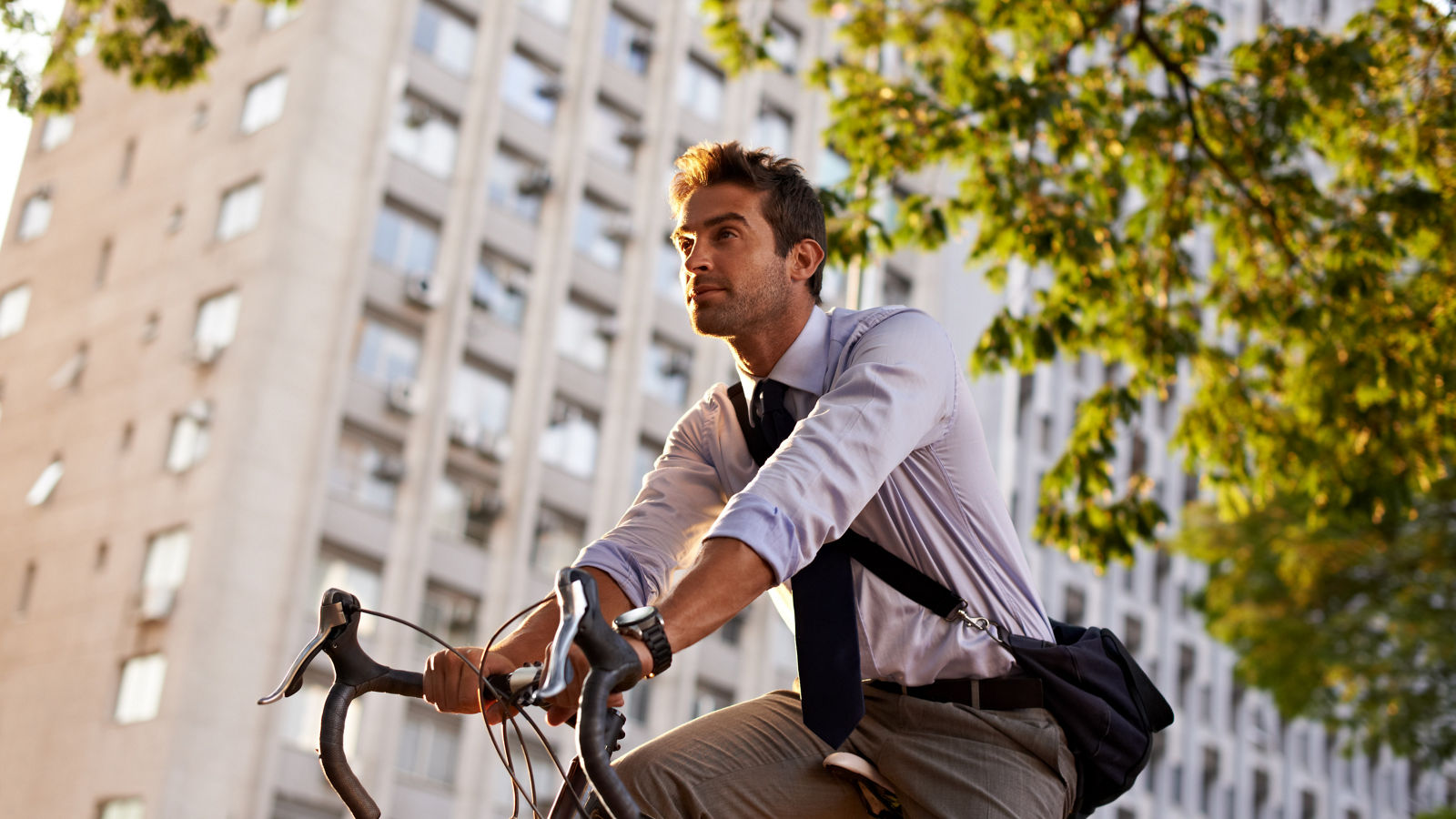 Off to work on his wheels. Shot of a businessman commuting to work with his bicycle.