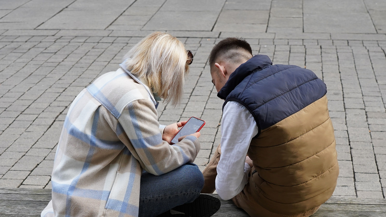 young couple looks up smart phone,junges paar schaut aufs smartphone