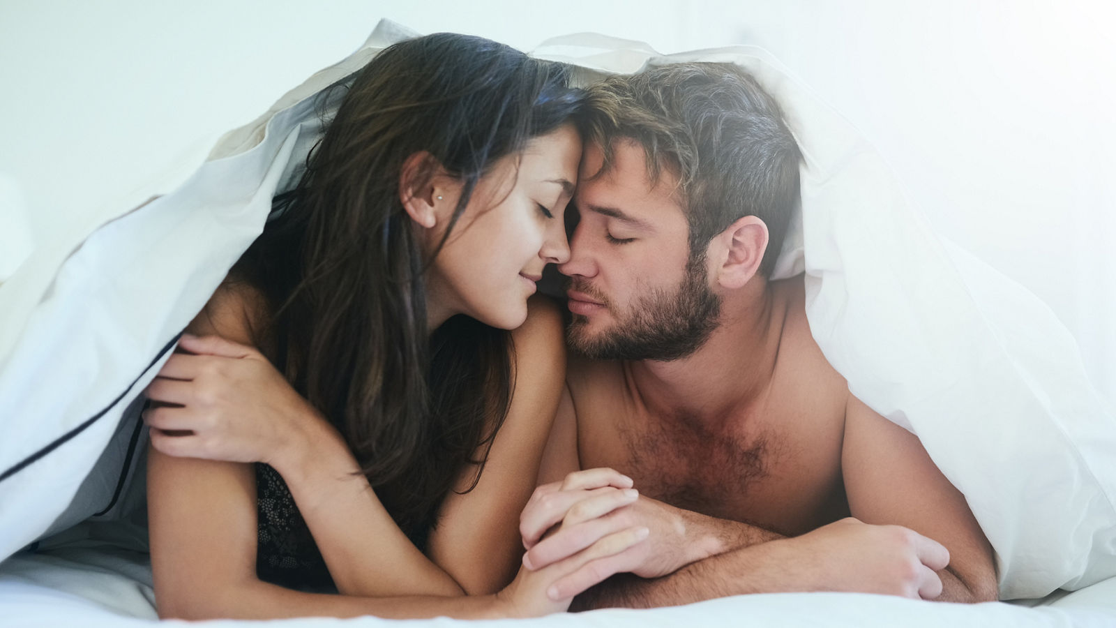 I am more in love with you than ever. Shot of a young couple having an intimate moment under the covers.