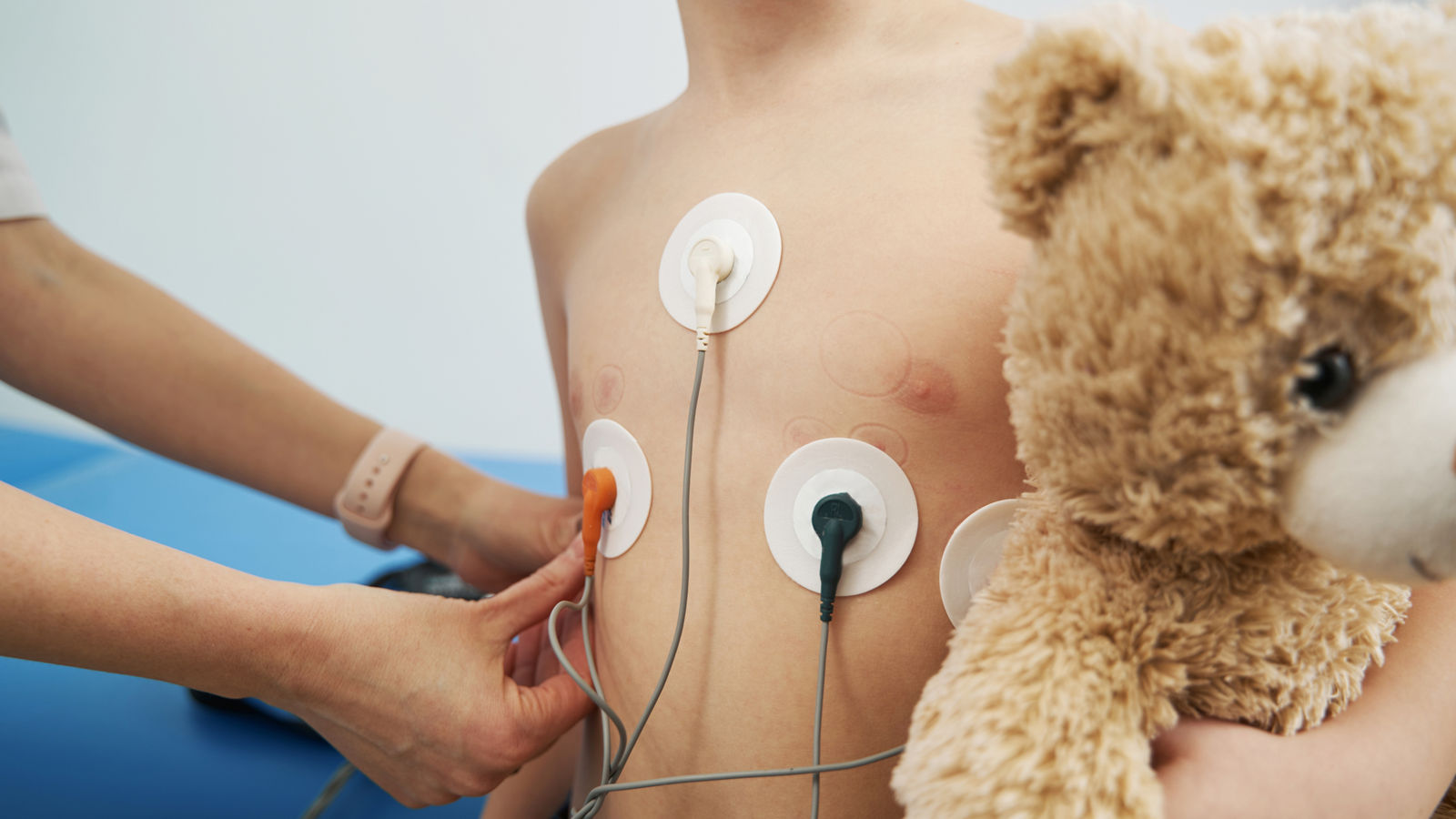 Pediatrician checking child heart rhythm with ECG holter monitor