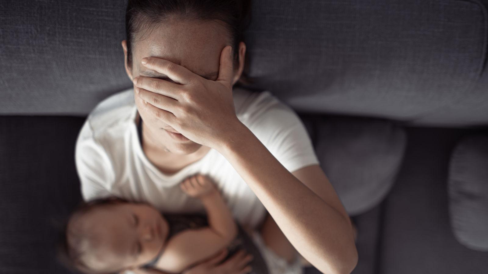 tired and exhausted mother holding baby