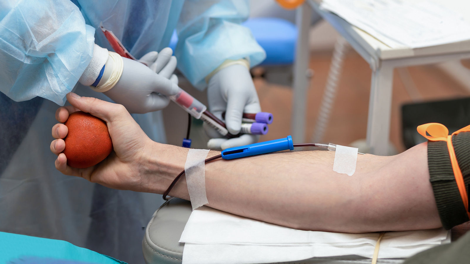 bone marrow donation. male hand holding red ball, man with blood transfusion system, blood bag. soft focus,bone marrow donation. male hand holding red ball, man with blood