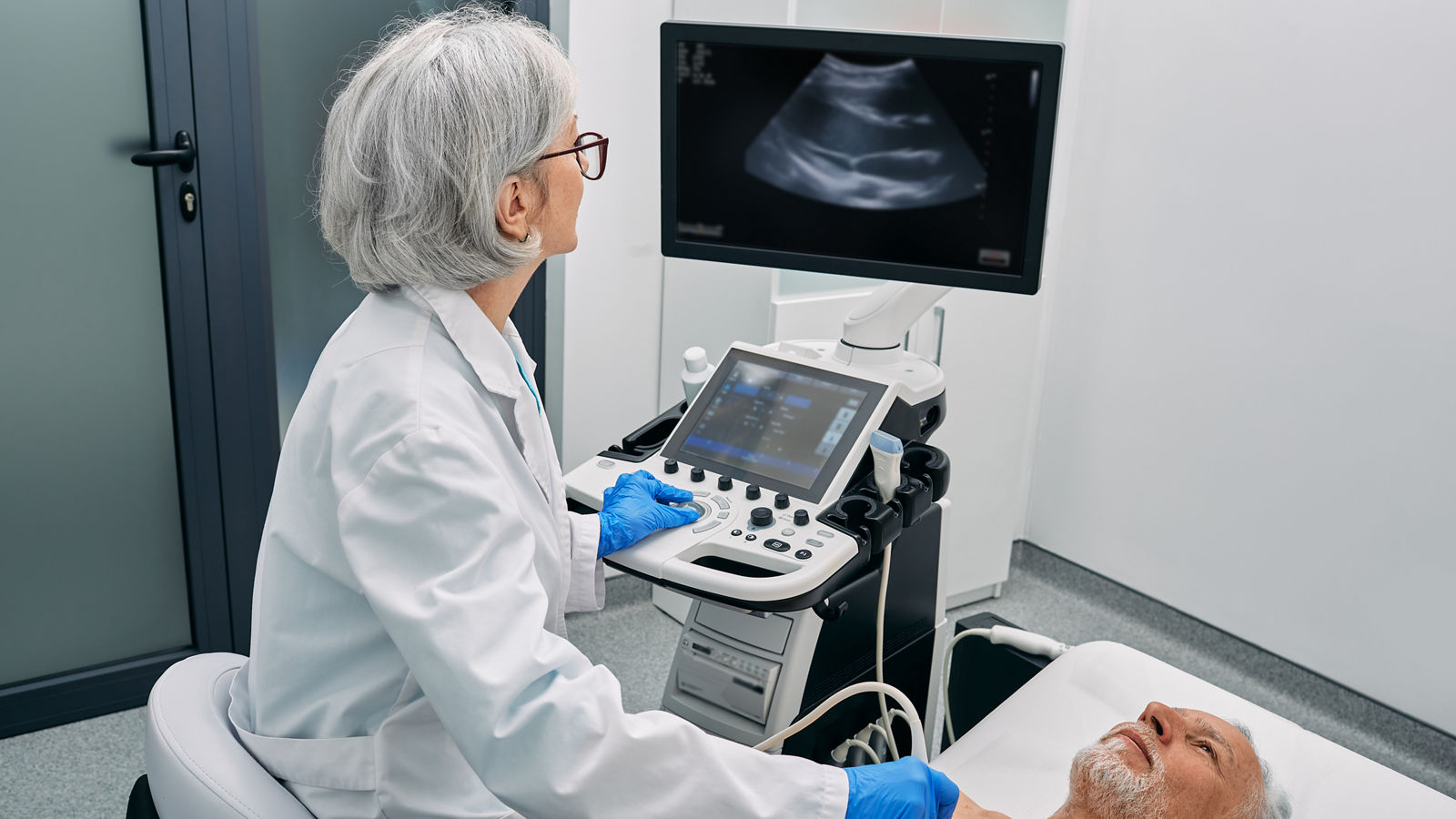 Heart ultrasound exam for senior man with ultrasound specialist while medical exam at hospital