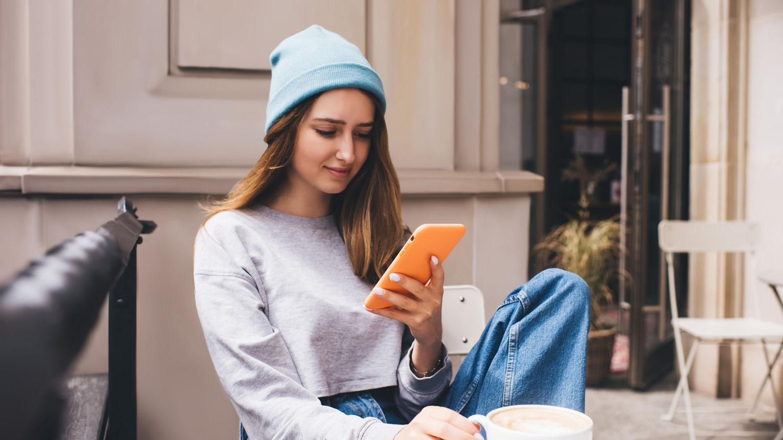 Young millennial female using social network application on mobile phone for communication. Caucasian hipster girl holding smartphone in silicone case. Teenager browsing online with internet data,Young millennial female using social network application on mobi