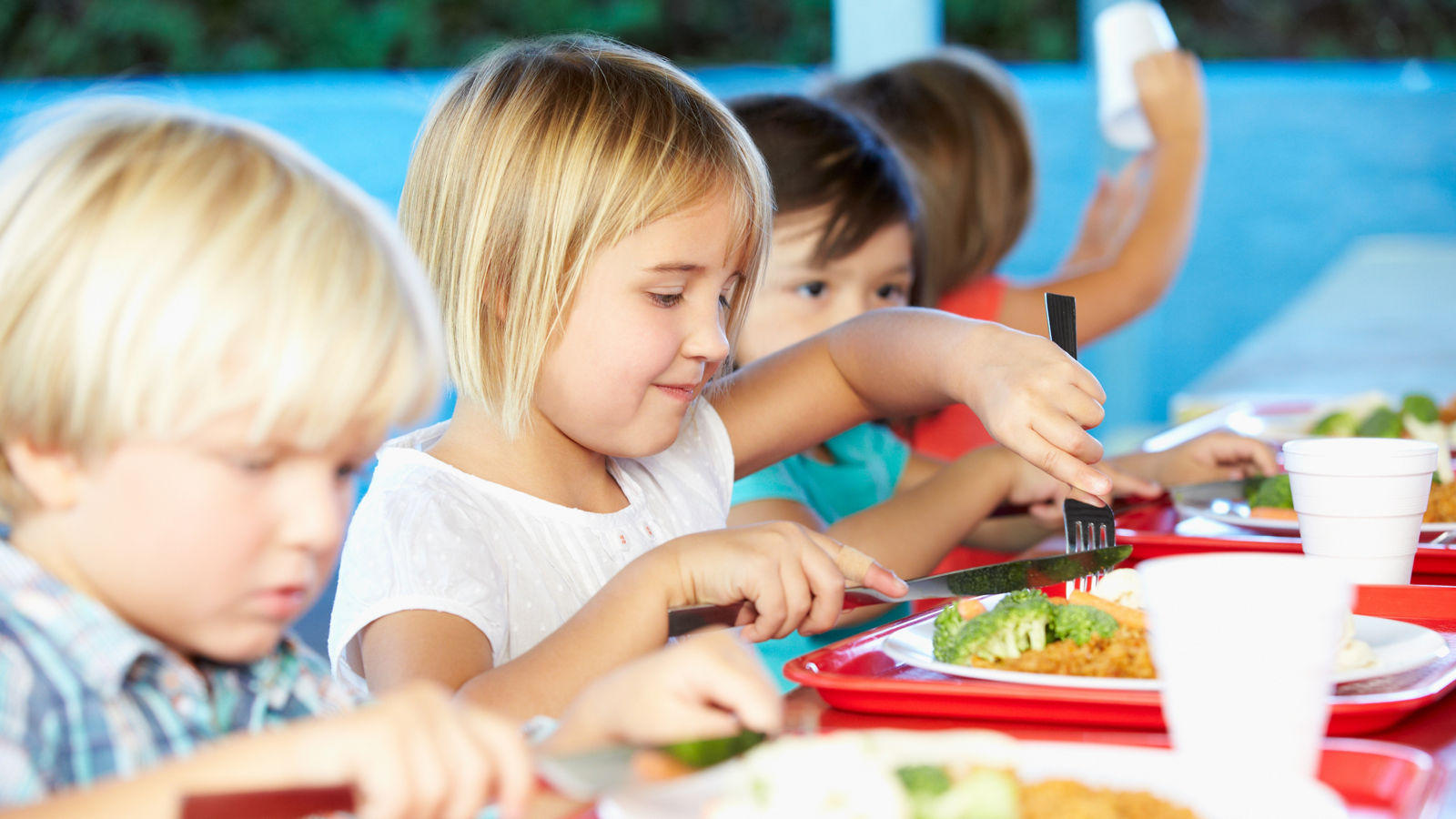 Elementary Pupils Enjoying Healthy Lunch In Cafeteria