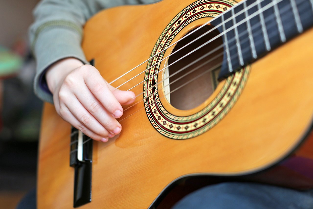 Gitarre die von einem Kind gespielt wird 