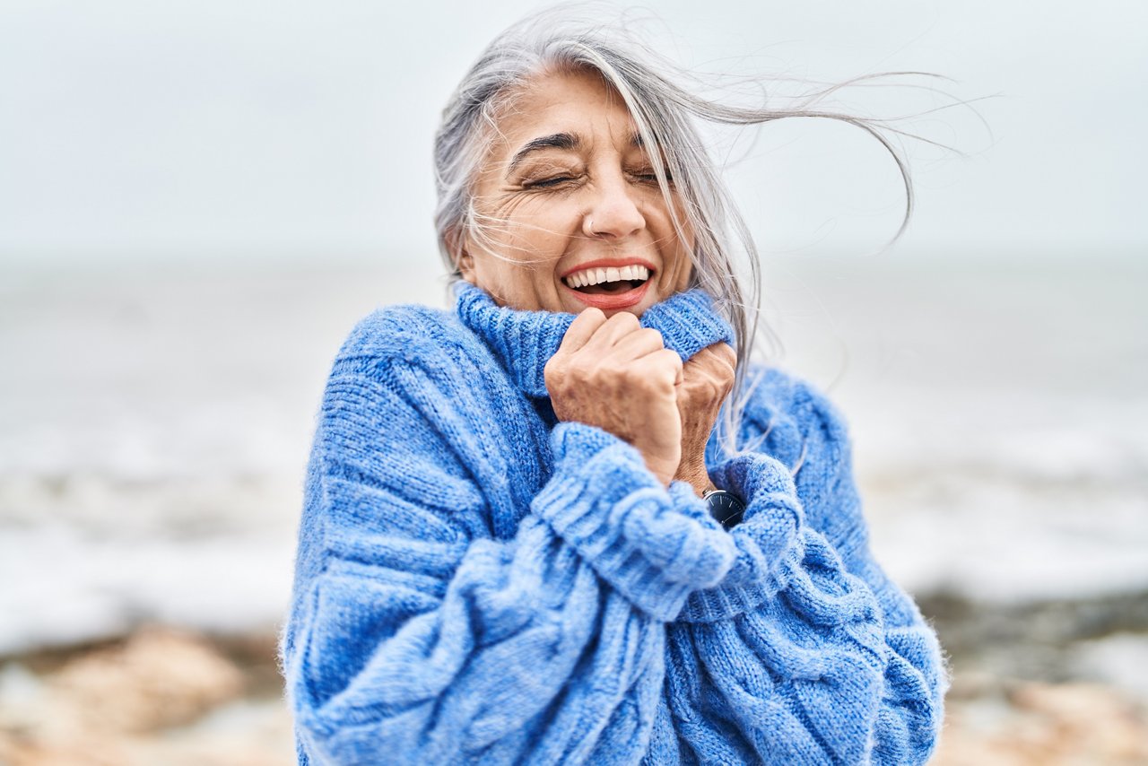 Middle age grey-haired woman smiling confident standing at seaside