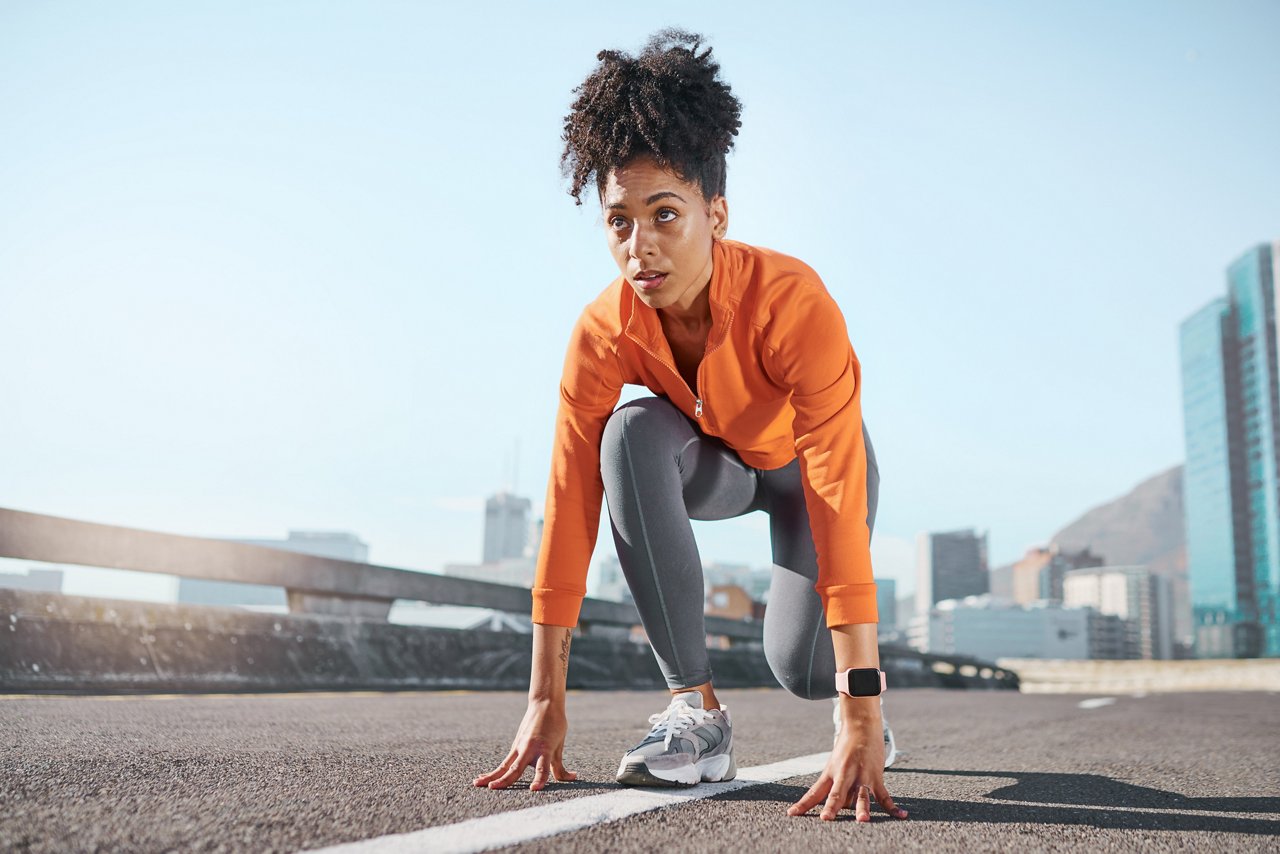 Runner, black woman and street for race, start or sprint in exercise, workout and training in city. Woman, focus and running for fitness, sport and health on road, metro or urban town in sunshine.