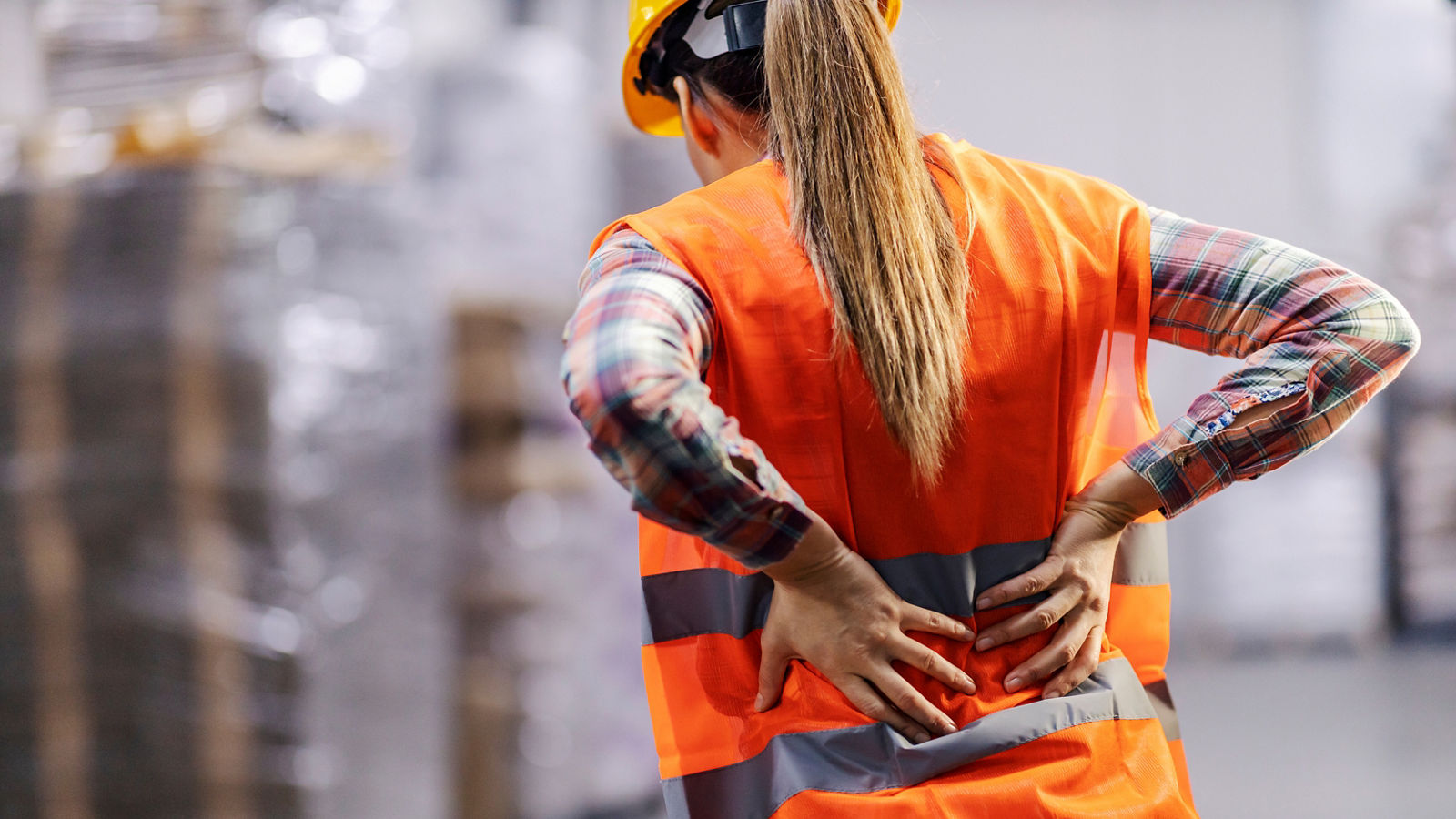 A storage worker having back pain and holding spine.