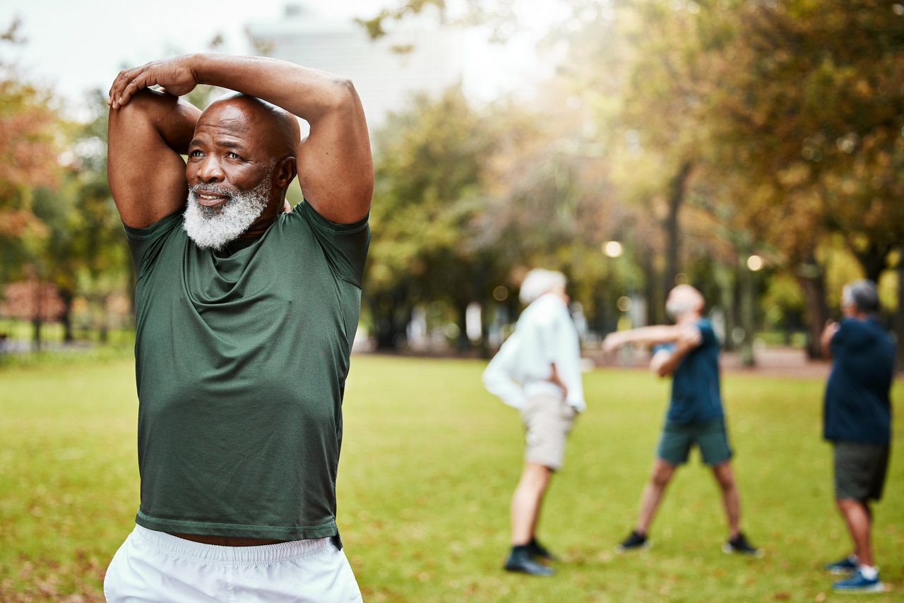 Black man, exercise and senior stretching in park, fitness and workout, energy and healthy lifestyle outdoors. African old man training with motivation in nature for strong body, wellness and sports.