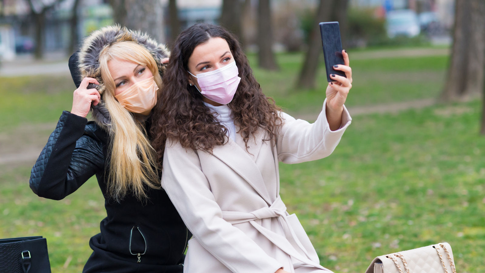 Two young women in the city wearing masks and gloves during corona virus pandemic