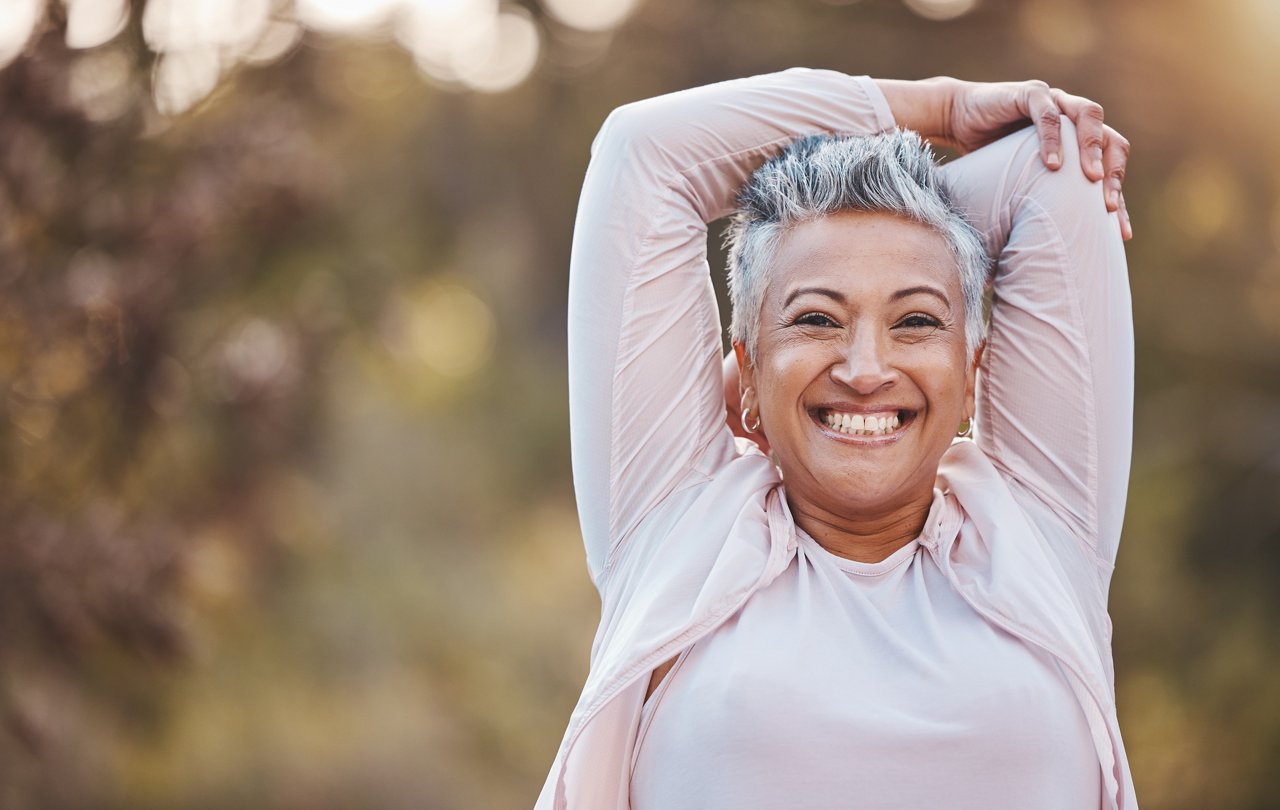 Fitness, portrait or happy old woman stretching in nature to start training, body exercise or hiking workout in Portugal. Freedom, face or healthy senior person smiles with pride, goals or motivation.