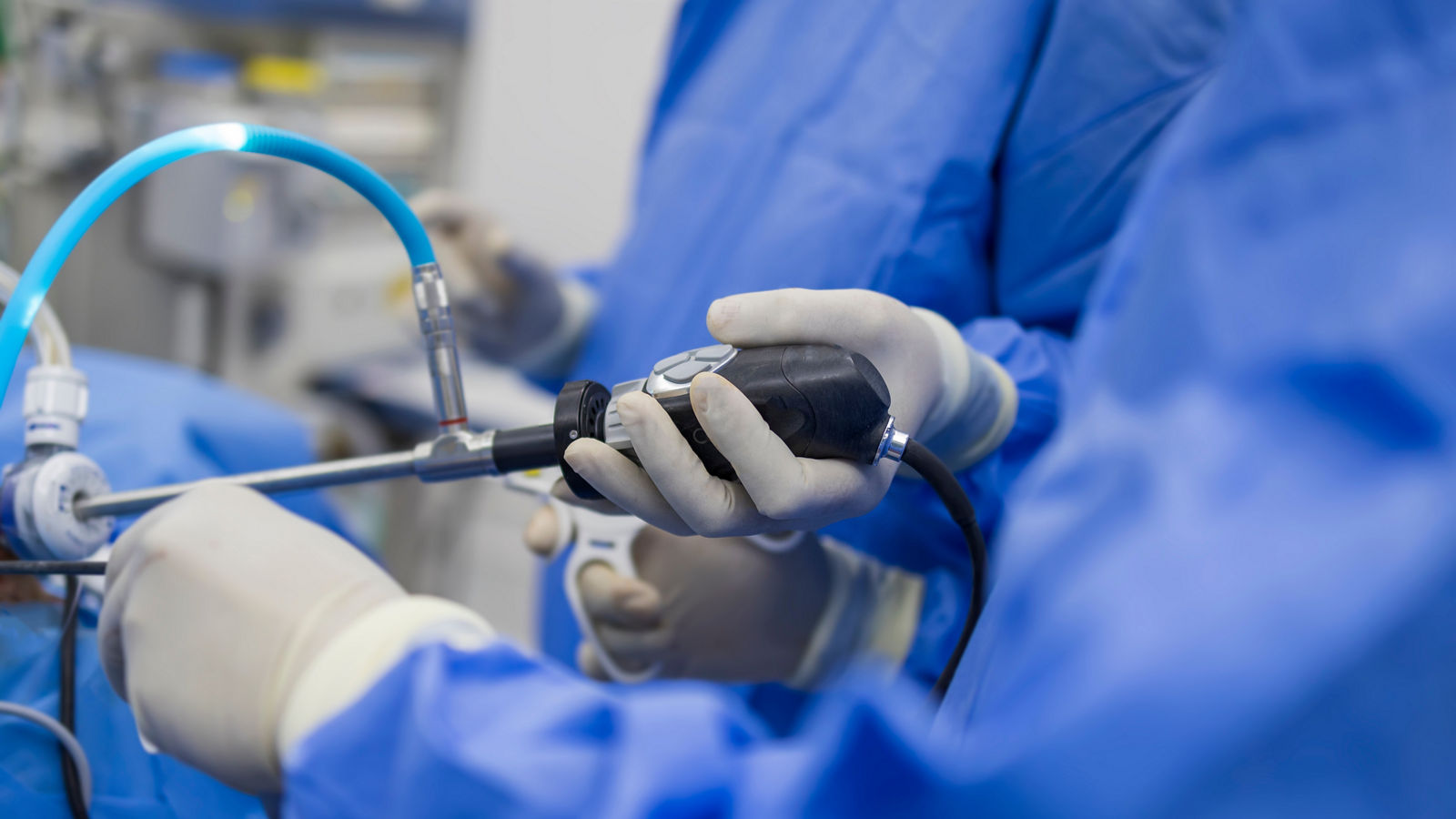 Surgeon perform laparoscopic cholecystectomy in gall stone patient with abdominal pain.Doctor and scrub nurse in blue surgical gown suit doing keyhole surgery inside operating room.Medical concept.