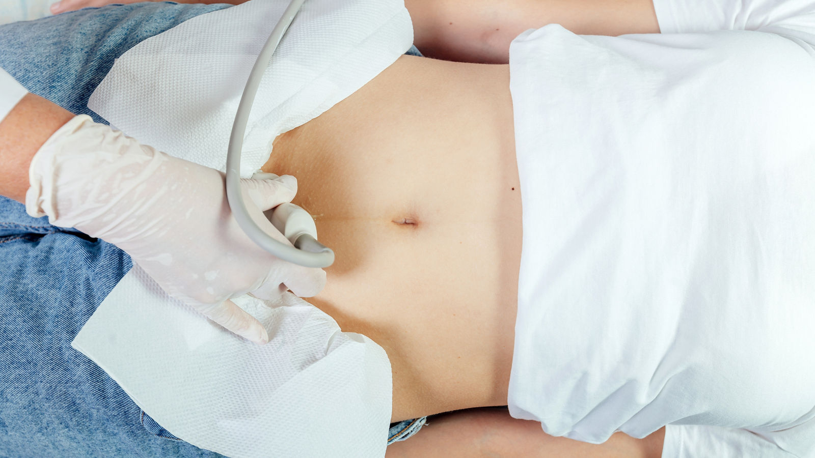 Doctor ultrasound examine female patient abdomen at hospital