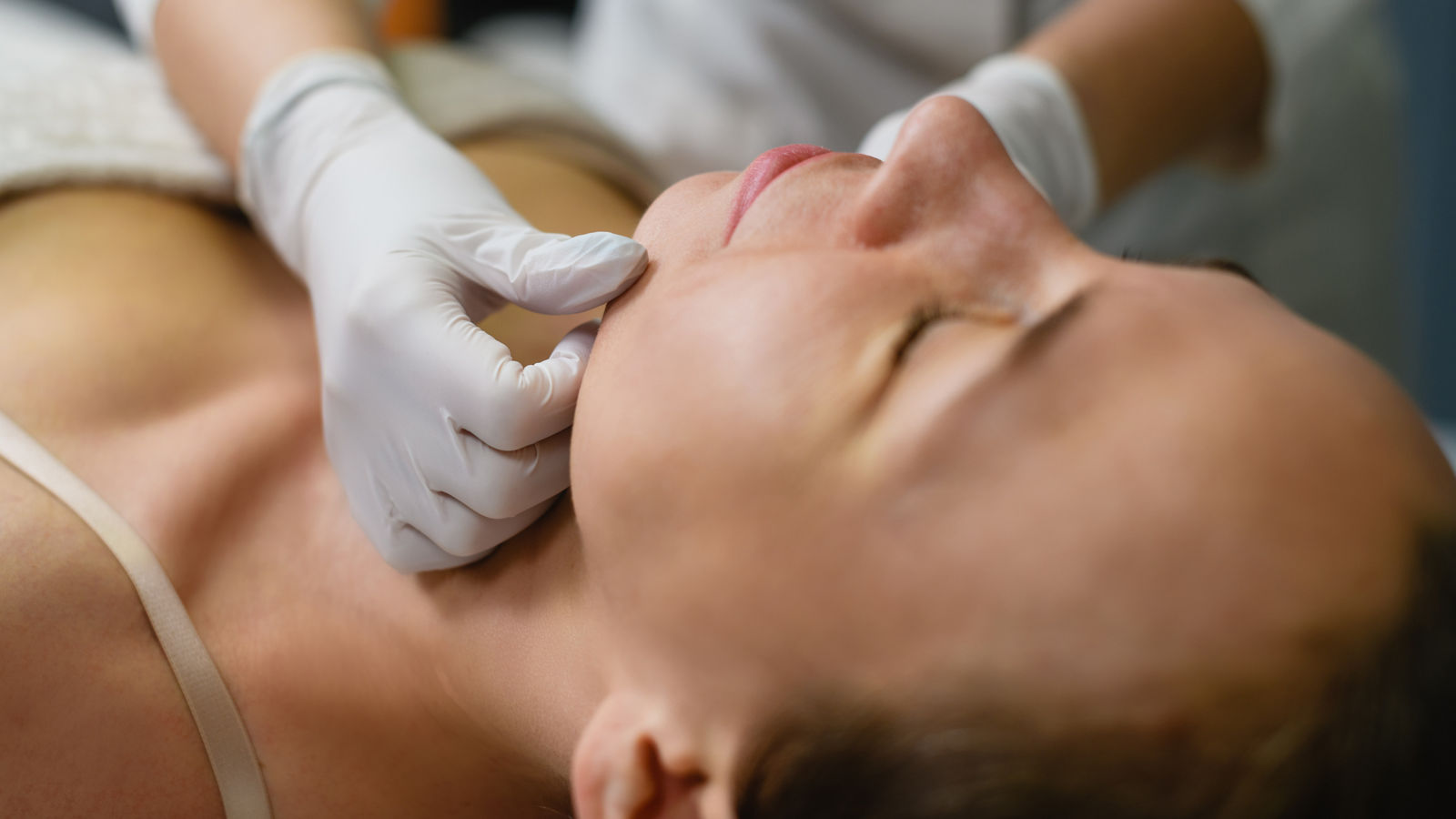 Woman lay down in cosmetology beauty clinic