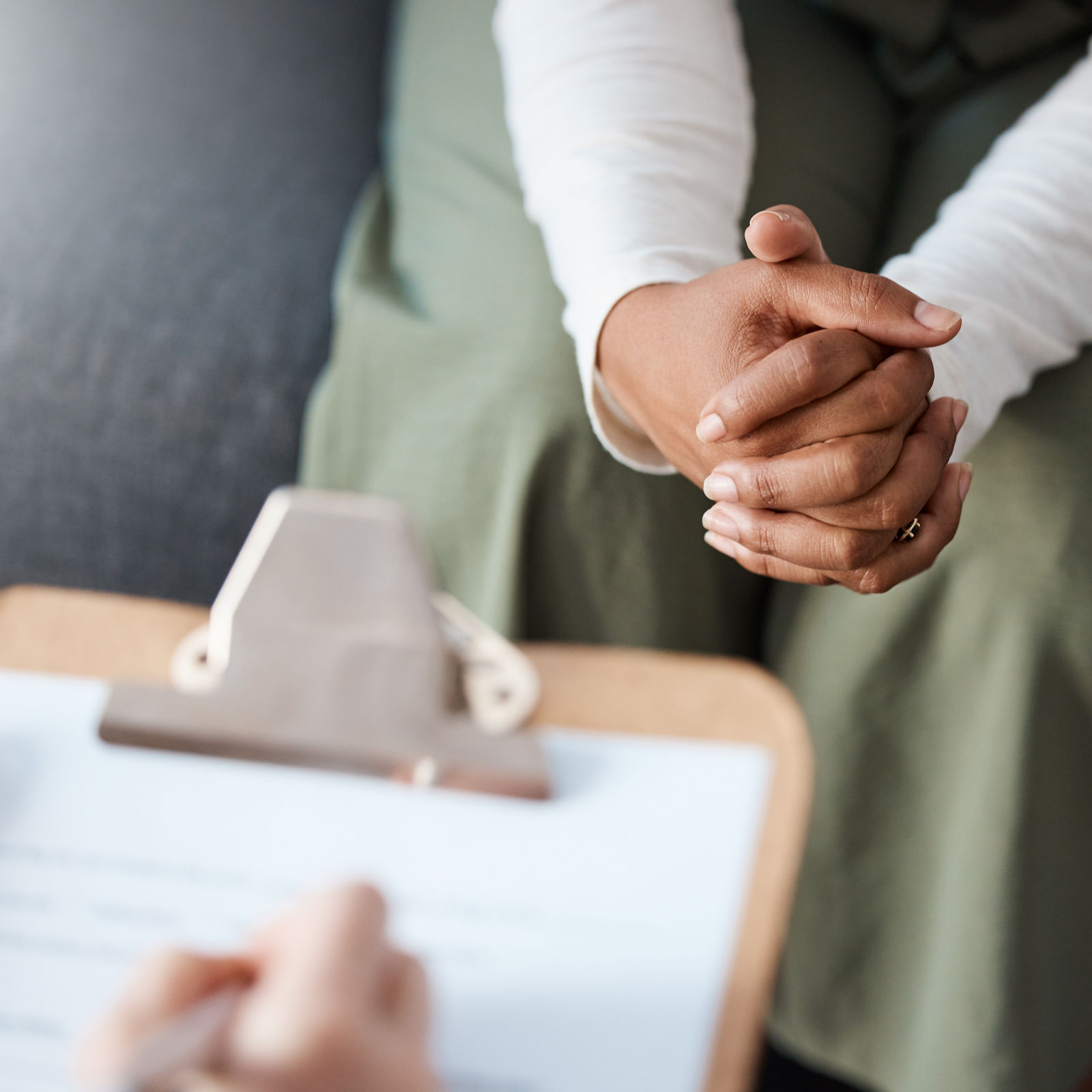 Woman, hands and therapist writing on clipboard in consultation for mental health, psychology or healthcare. Hand of female person or psychologist consulting patient with anxiety or stress in therapy.