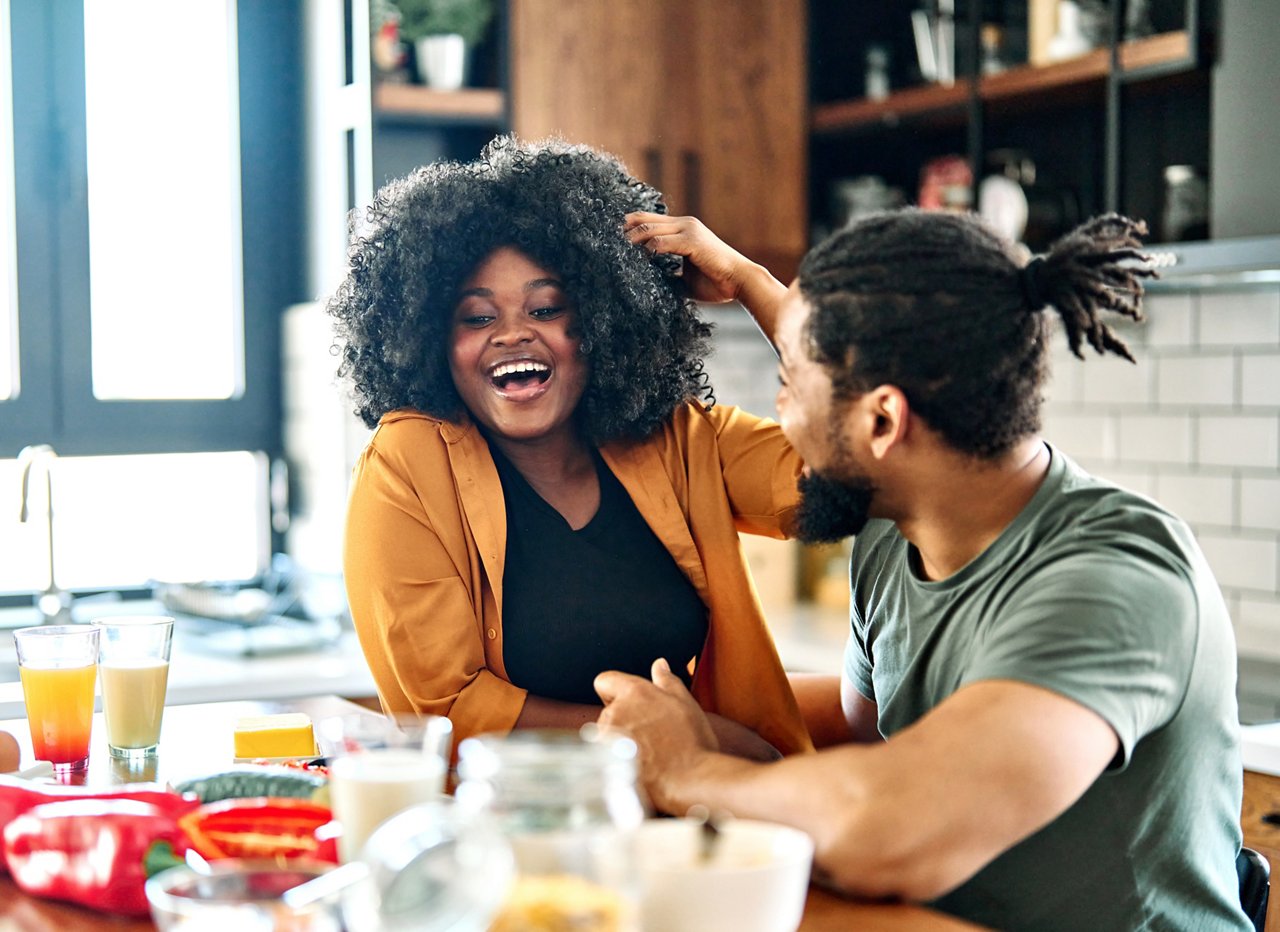 Happy young afro american couple having fun preparing food  in kitchen