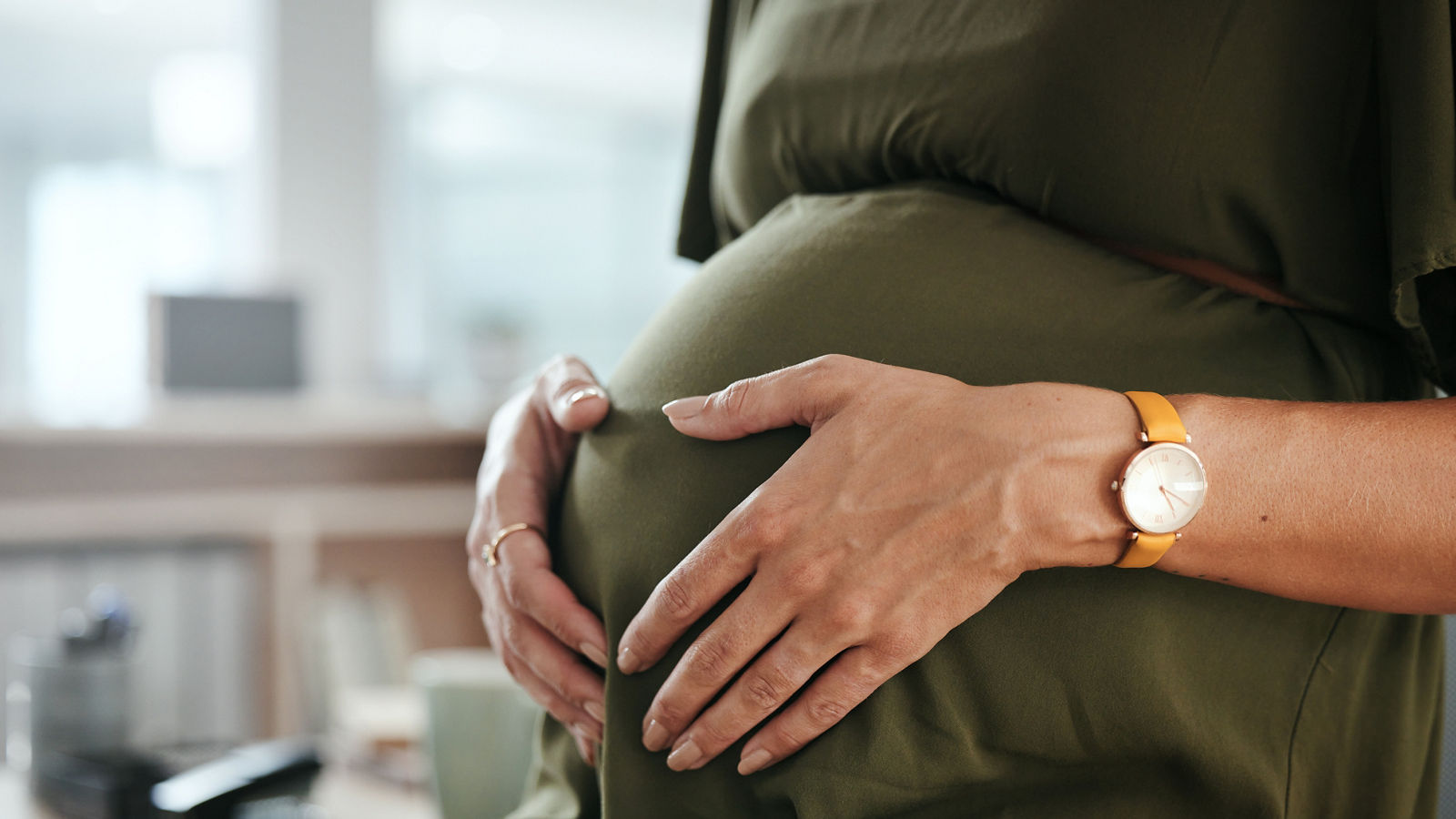 Worker, office and pregnant with hands, stomach and relax for break, company and workplace. Woman, employee or pregnancy in career, work or job with love, affection or care for baby, closeup or belly