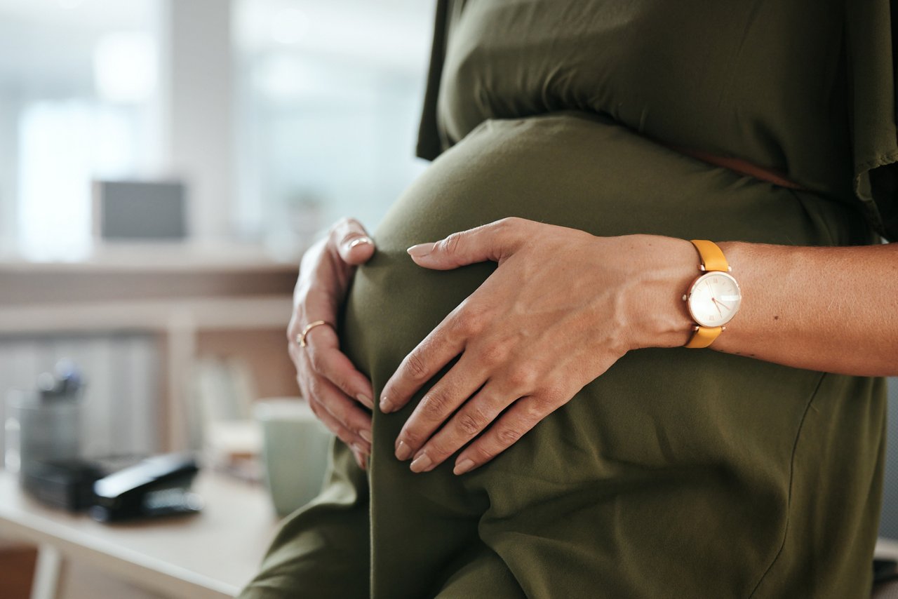 Worker, office and pregnant with hands, stomach and relax for break, company and workplace. Woman, employee or pregnancy in career, work or job with love, affection or care for baby, closeup or belly.