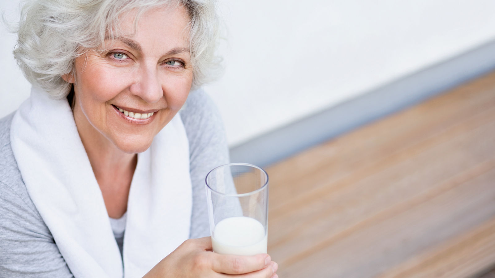 Seniorin mit einem Glas Milch