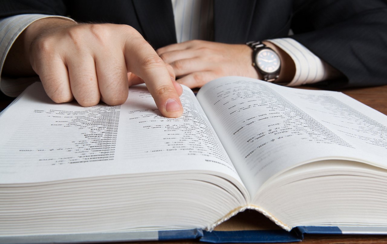 man looking in the large dictionary close up