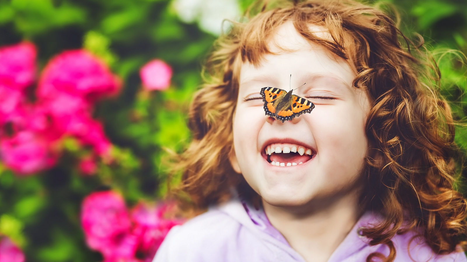 Laughing girl with a butterfly on his nose.