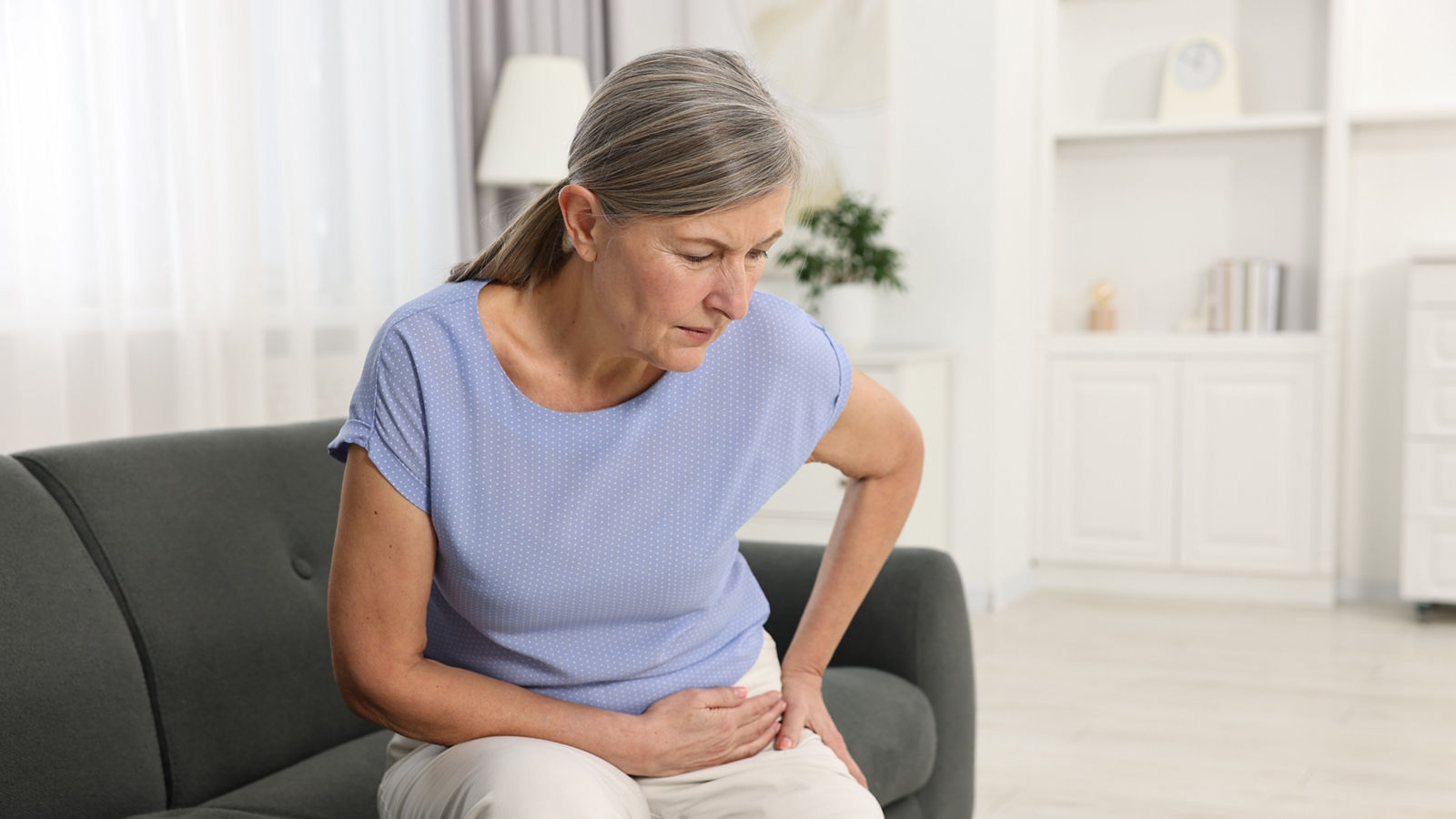 Arthritis symptoms. Woman suffering from hip joint pain at home