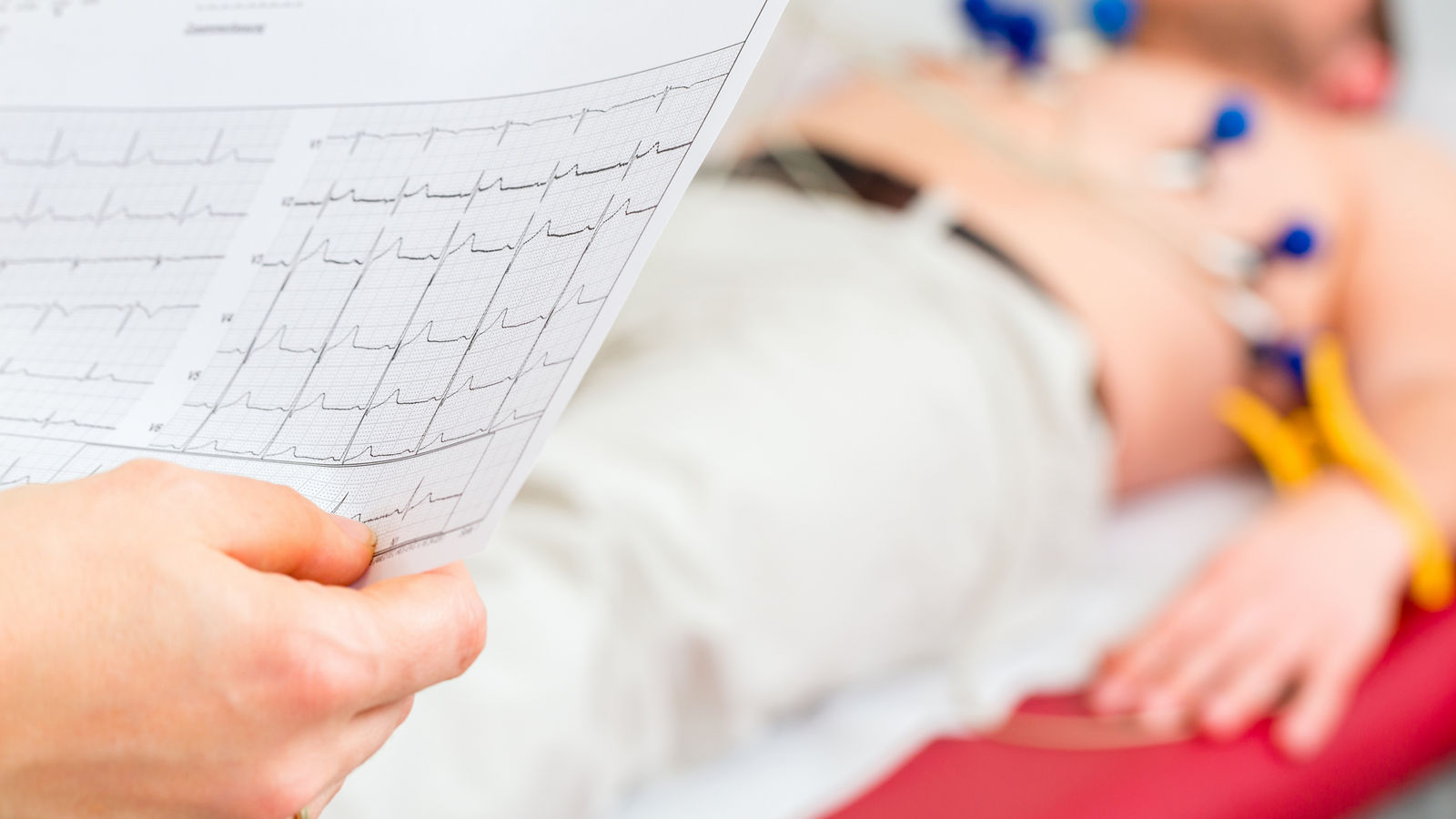 Doktor kontrolliert Patient EKG in Arztpraxis