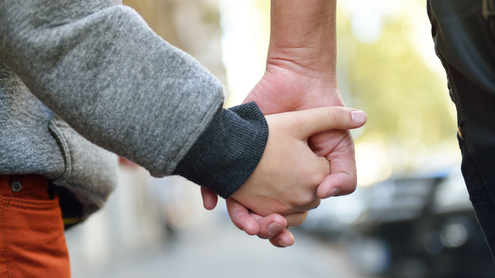 Hands of mother and child outdoor closeup. Mother holds hand of her son walking city.,Hands of mother and child outdoor closeup. Mother holds hand of 