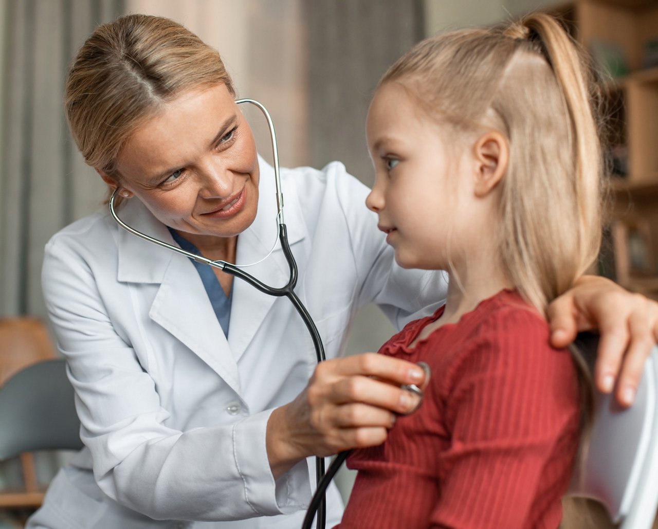 kardiologische Ärztin untersucht  das Herz eines Kindes mit einem Stethoskop