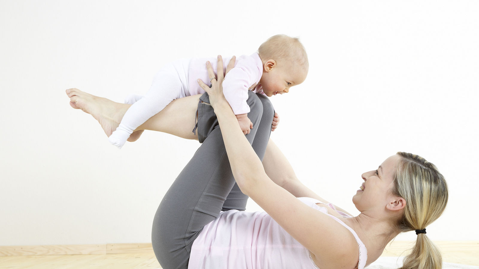 junge mama macht gemeinsam mit ihrem baby fitness und yoga uebungen