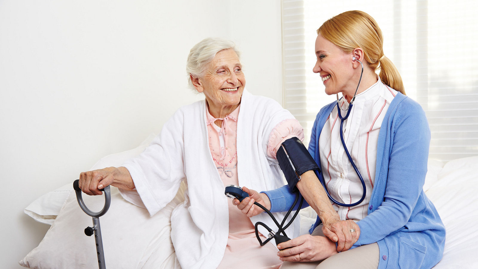 Krankenschwester misst Blutdruck bei Senioren