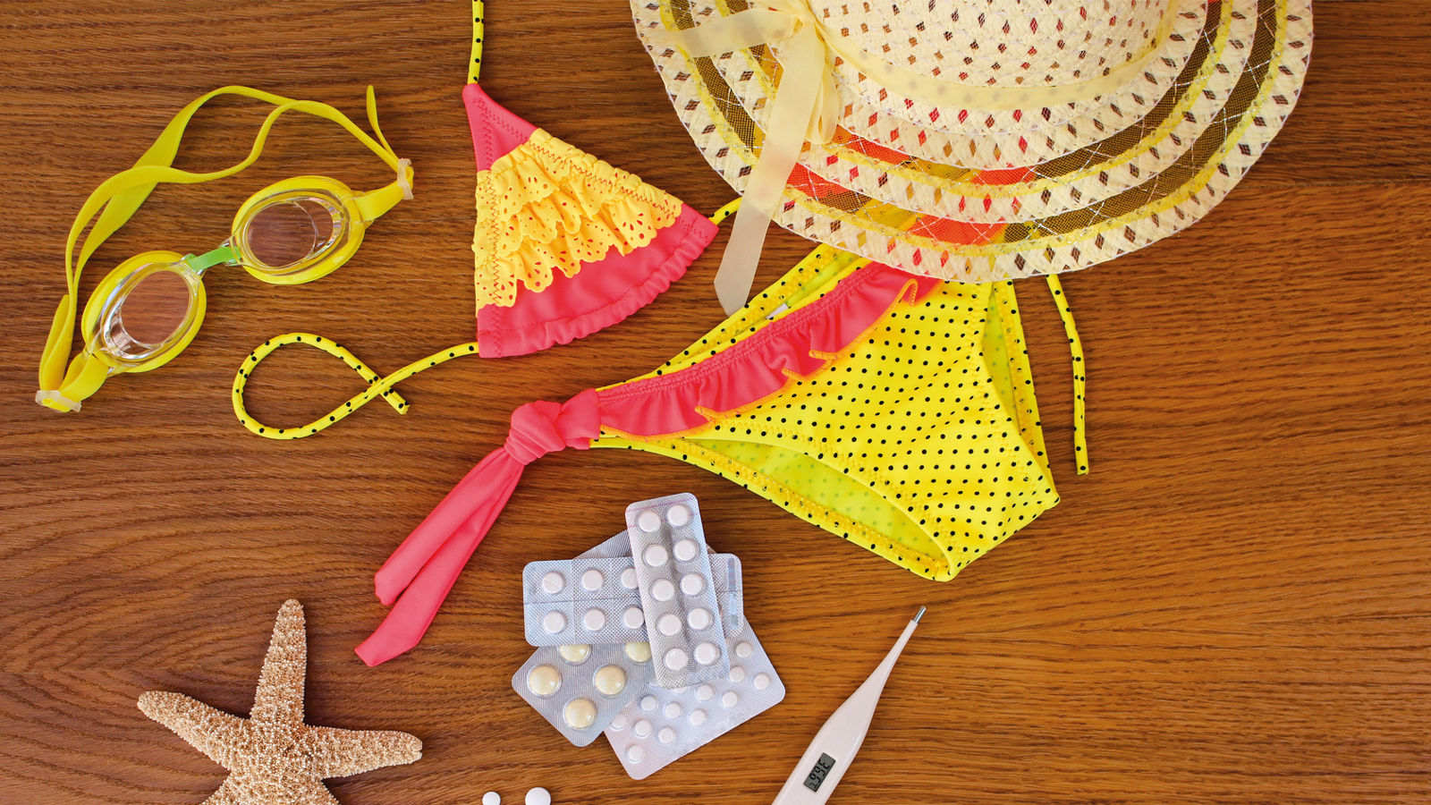 Summer beach accessories and medicine on the table. The concept of medication required in the journey