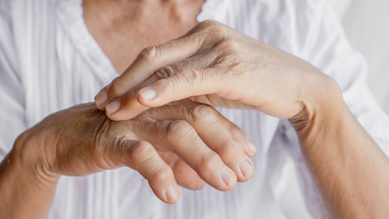 female patient massaging hand and fingers having problem with gout and joint pain 