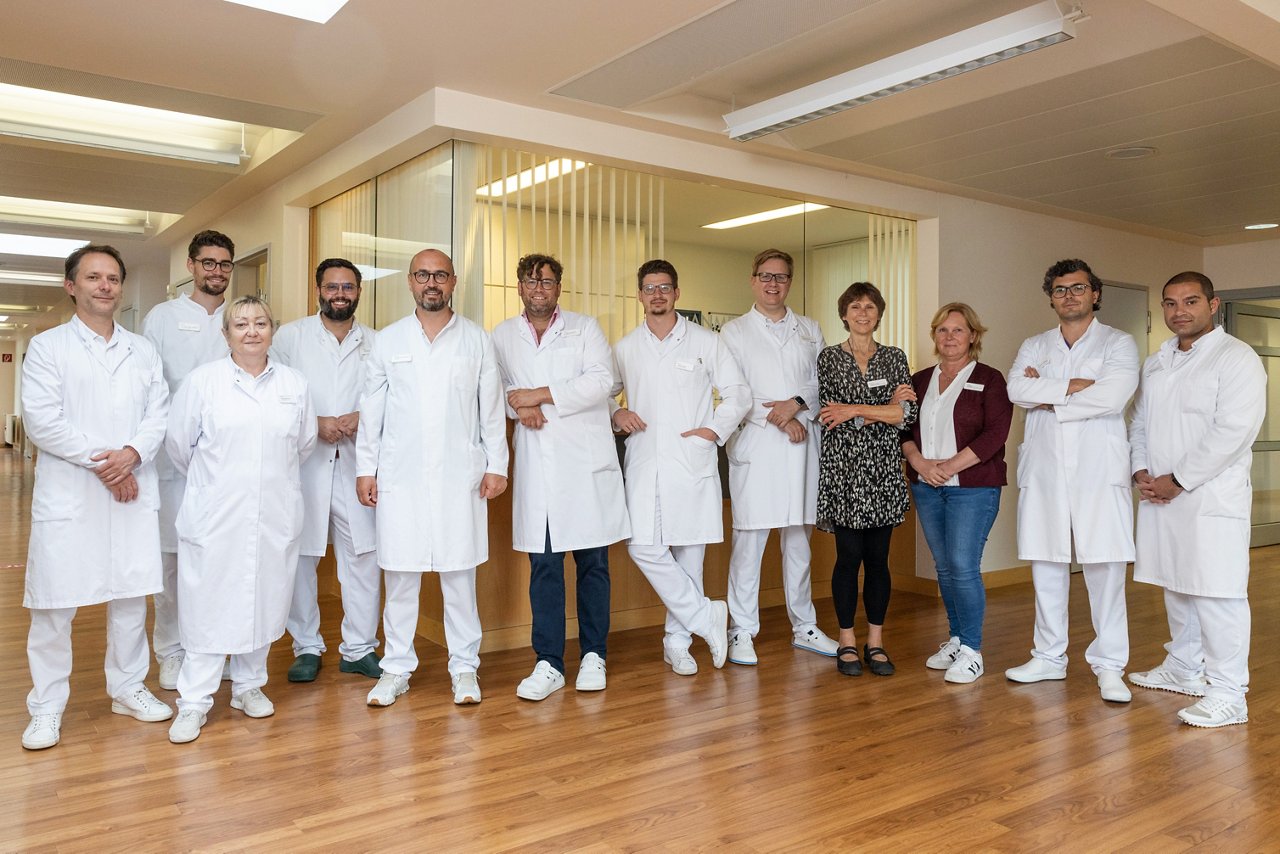 Team der Urologie steht im Gruppenfoto zusammen im Flur. 