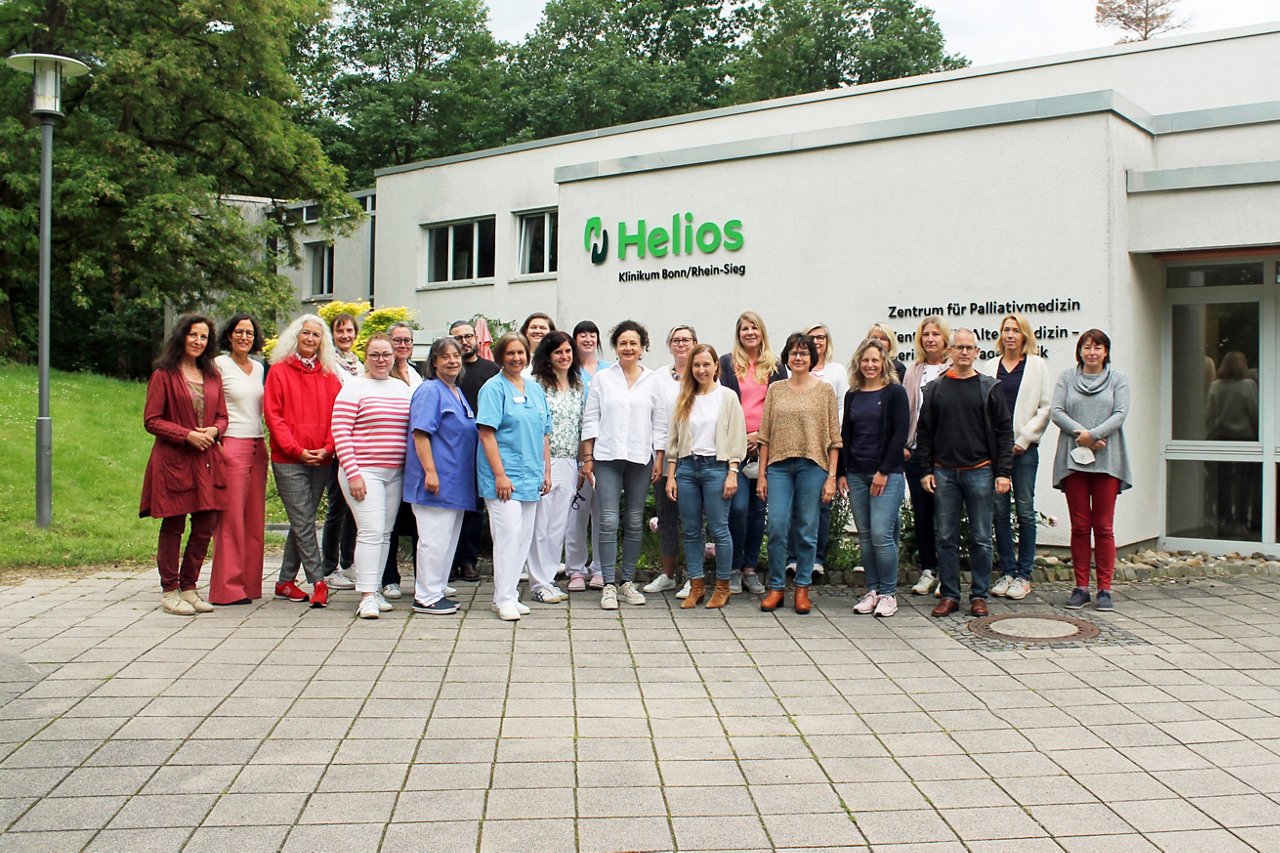 Gruppenfoto des Teams Palliativmedizin vor dem Gebäude