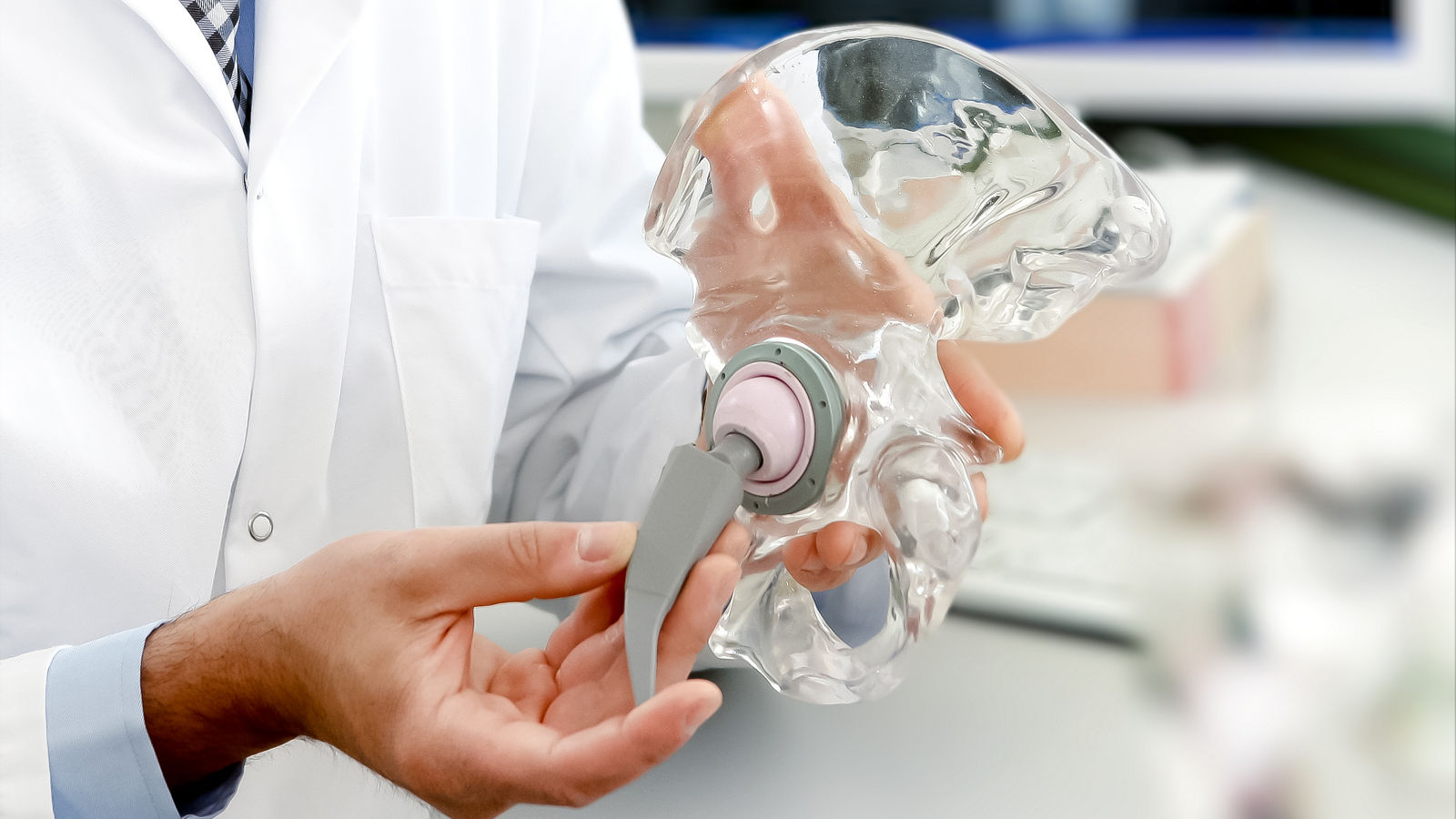 Arzt zeigt Hüftprothese