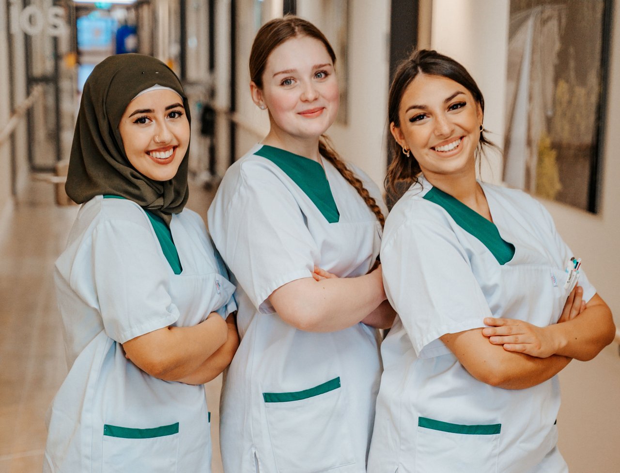 3 Auszubildende halb zu sehen mit den Armen verschränkt