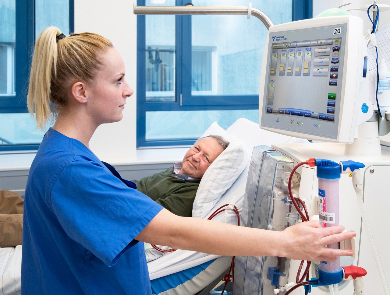Eine Pflegekraft stellt einen Patienten an der Dialysemaschine ein.