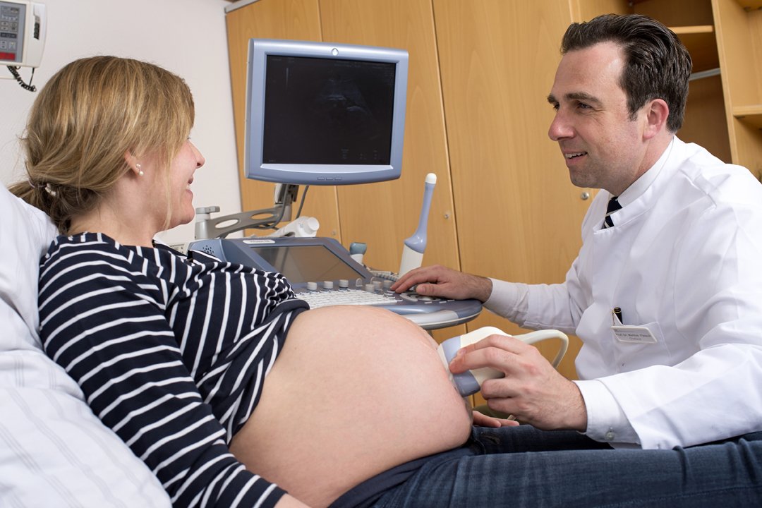 Chefarzt Prof. Fleisch führt bei einer Schwangeren einen Ultraschall durch.