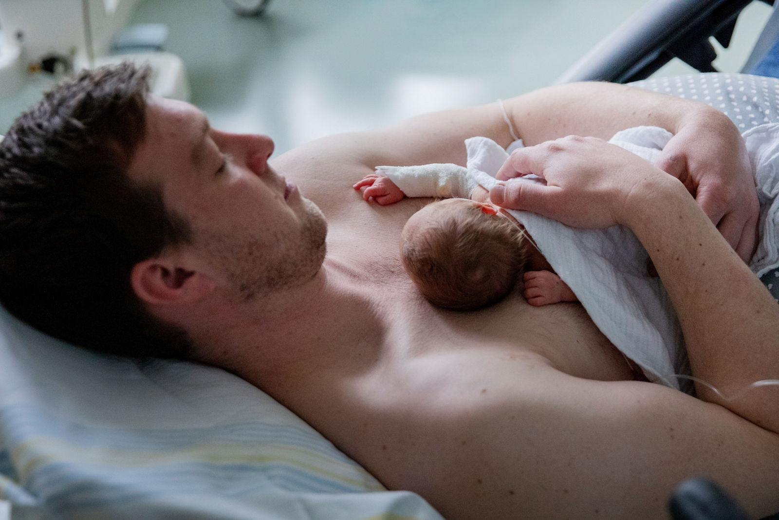 Papa hat sein Frühgeborenes zum Känguruhen auf der Brust