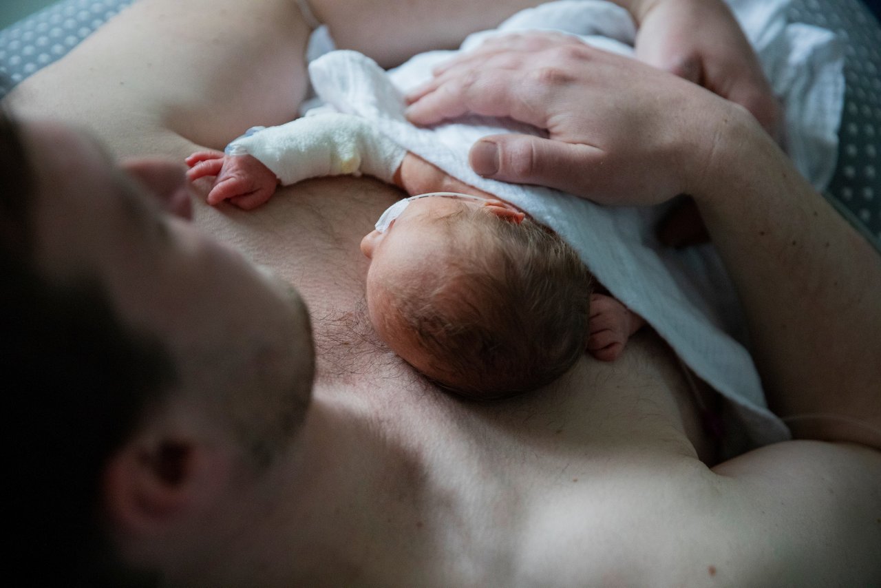 Papa hat sein Frühgeborenes zum Känguruhen auf der Brust
