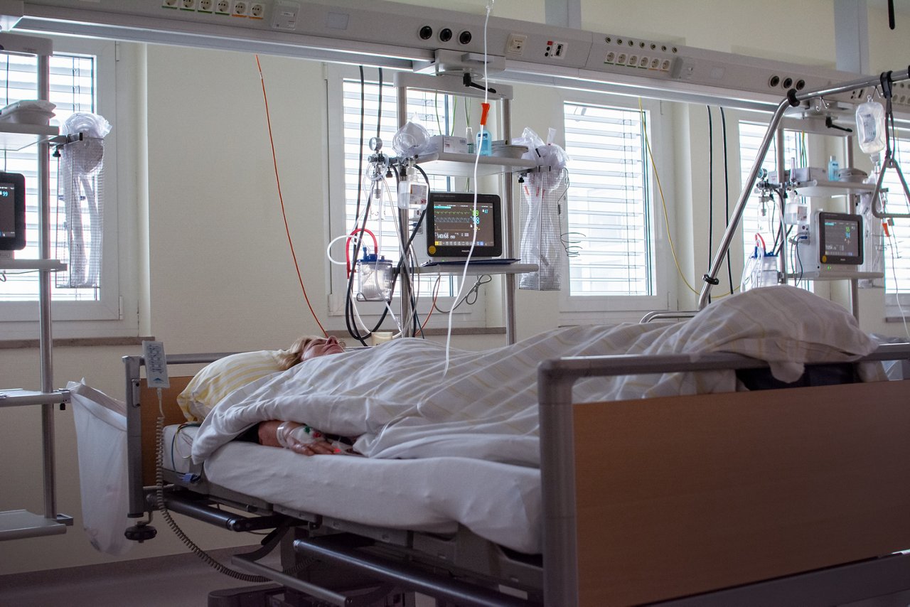 Patientin liegt im Bett des Aufwachraumes
