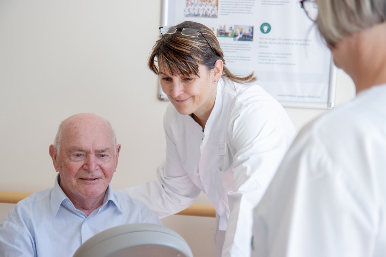 Chefärztin mit Patienten am Ergometer