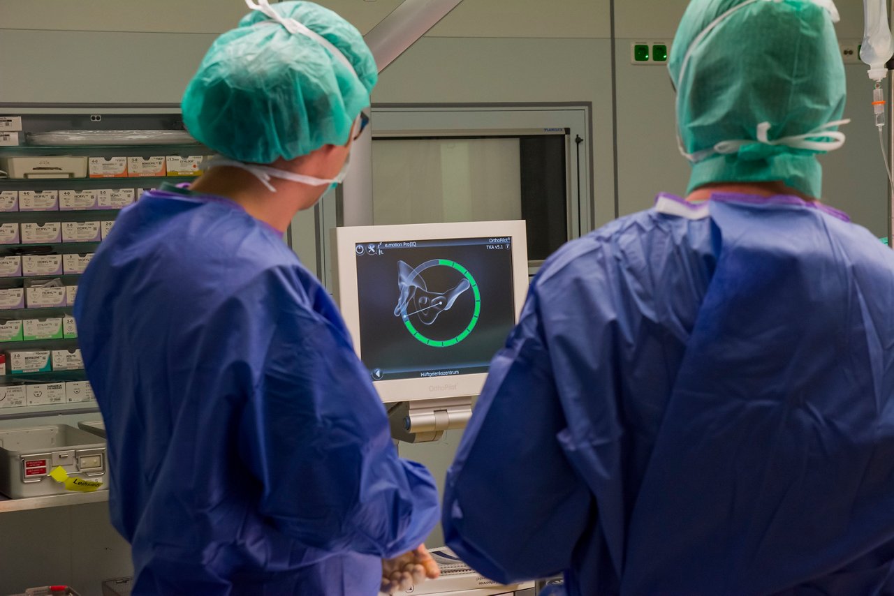 Ärzte während einer Knieoperation betrachten einen Bildschrim